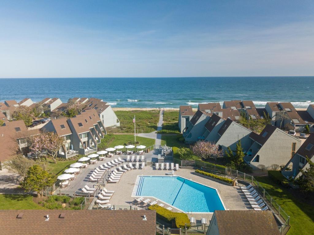 uma vista aérea de um resort com uma piscina e o oceano em The Surf Club Resort em Montauk