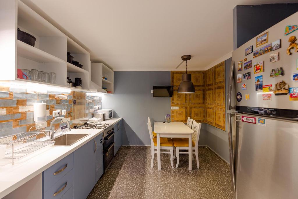 una cucina con tavolo e frigorifero di Batumi Surf Hostel a Batumi