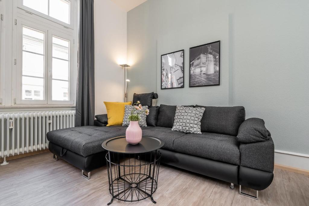 uma sala de estar com um sofá e uma mesa em Freiburg Appartements am Augustinerplatz em Friburgo em Brisgóvia