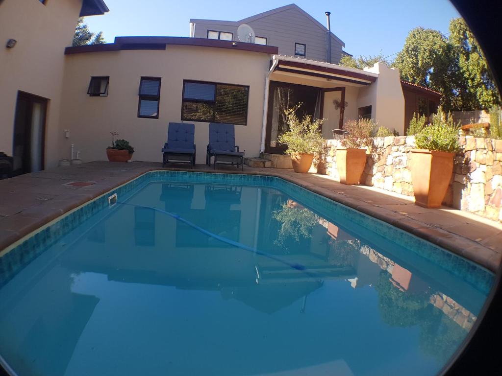 a swimming pool in front of a house at Malachite Cottage in Kommetjie