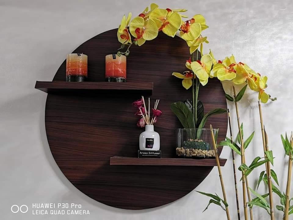 a circular wooden shelf with candles and flowers on it at EAM LAKE VIEW @ TAGAYTAY PRIME RESIDENCES in Tagaytay