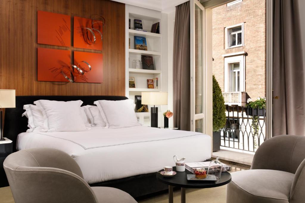 The First Dolce - Preferred Hotels & Resorts في روما: غرفة نوم بسرير ابيض كبير وكرسيين
