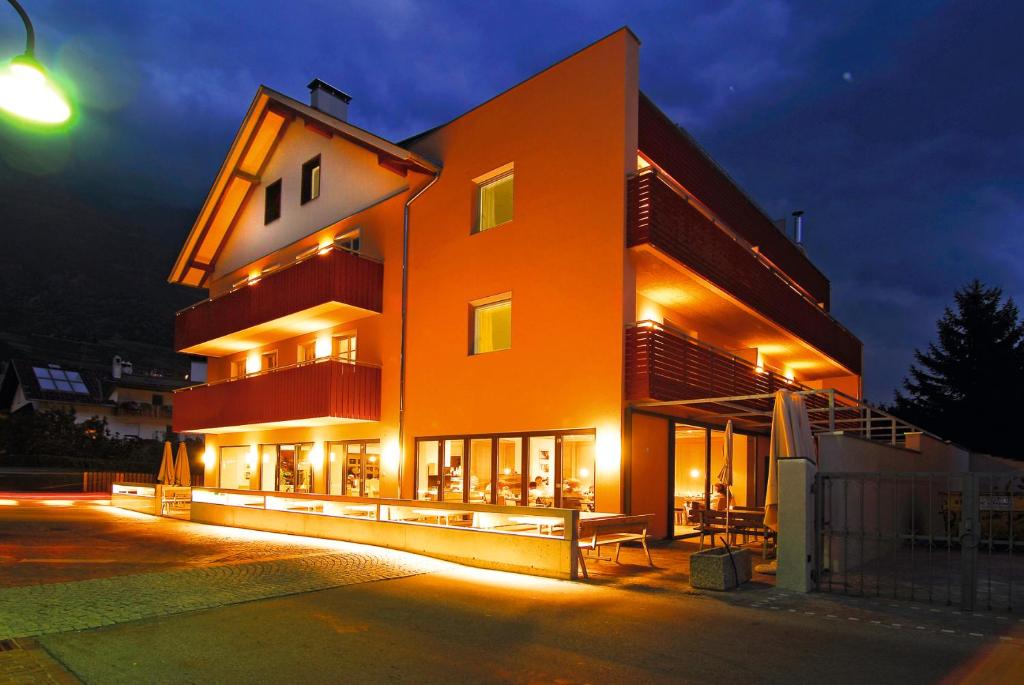Hotel Residence NATURNSERHOF في ناتورنو: مبنى به واجهة مضاءة في الليل