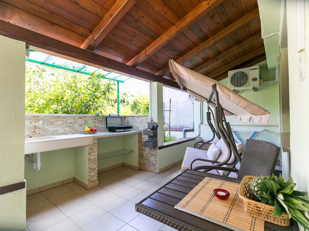 eine Terrasse mit einem Tisch, einem Tisch und Stühlen in der Unterkunft Apartments Nada in Vrsar