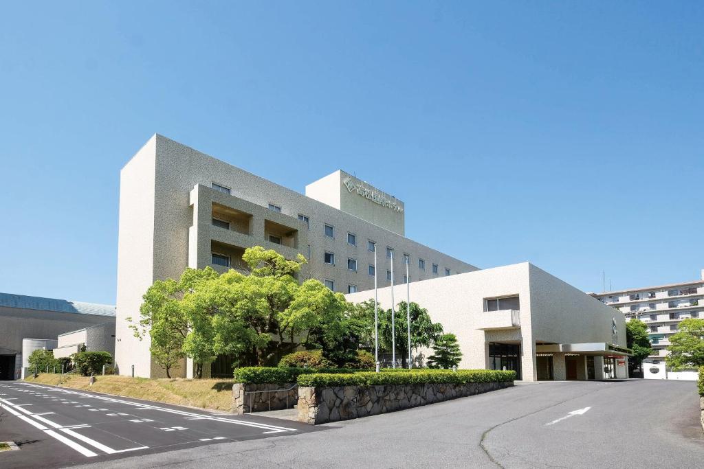 un gran edificio blanco con una carretera delante en Takamatsu Kokusai Hotel, en Takamatsu