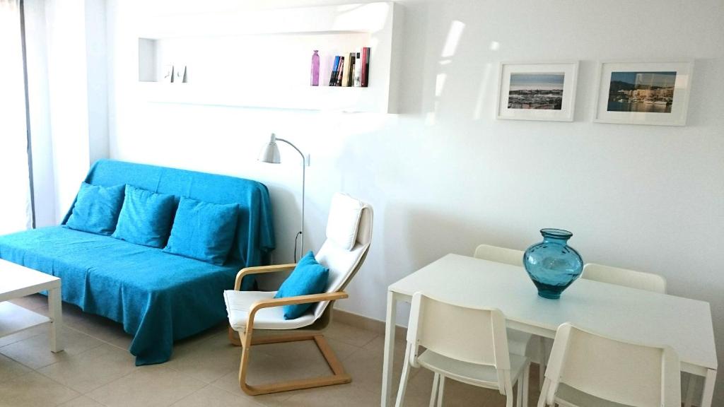 uma sala de estar com uma mesa e um sofá azul em Apartamento de dos dormitorios junto a Mojácar Playa em Garrucha