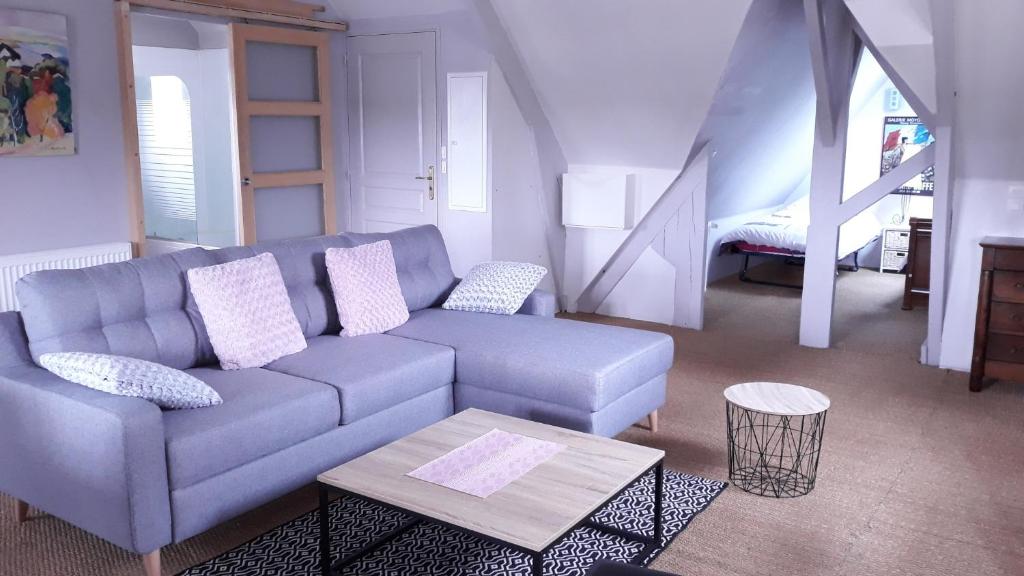 ein Wohnzimmer mit einem blauen Sofa und einem Tisch in der Unterkunft L'ecrin vannetais in Vannes