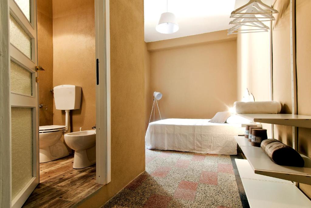 sypialnia z łóżkiem i łazienką z toaletą w obiekcie BluLassù City Center Rooms w Cagliari