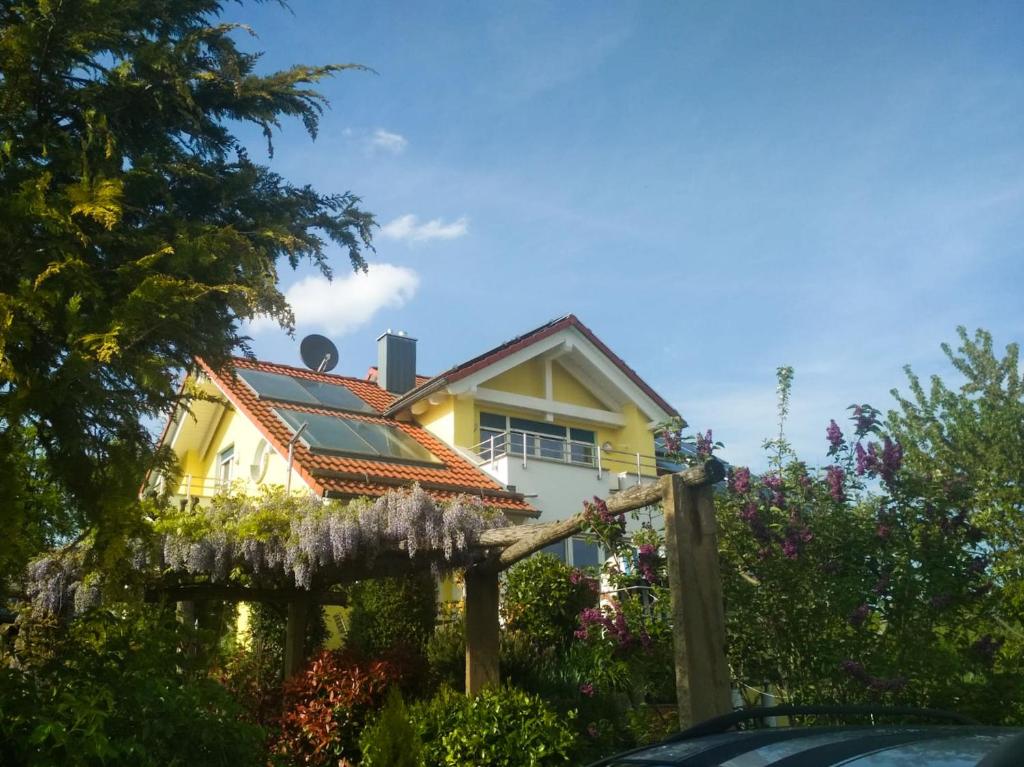 een geel huis met bloemen ervoor bij Schoenbuchjuwel in Walddorf