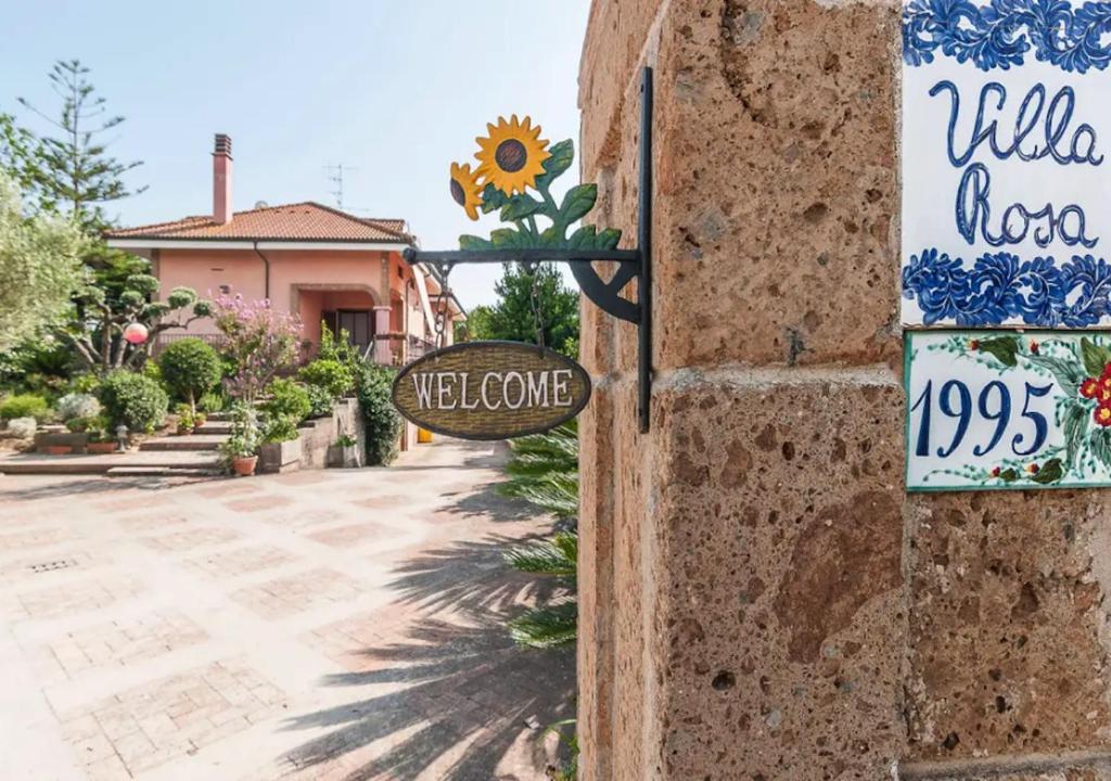 um sinal ao lado de uma casa com um sinal de boas-vindas em Villa Rosa Lifestyle B&B em Sessa Aurunca