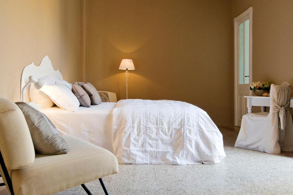 1 dormitorio con 2 camas y 1 silla en BluLassù City Center Rooms en Cagliari