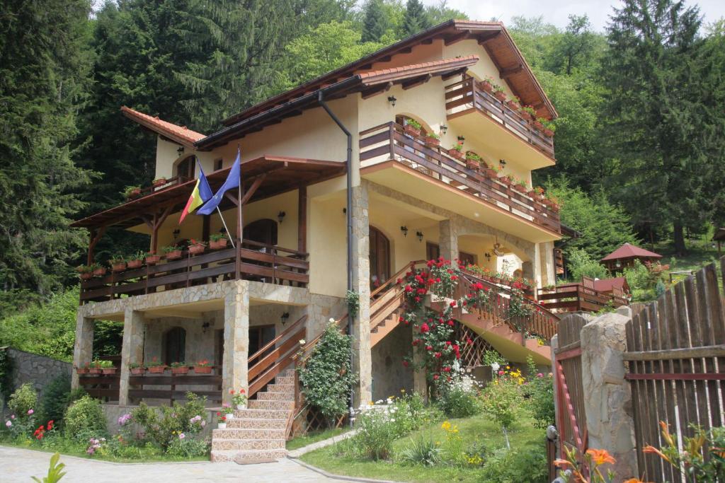 une maison avec un balcon et des fleurs devant elle dans l'établissement Casa Anca Boutique Hotel, à Braşov