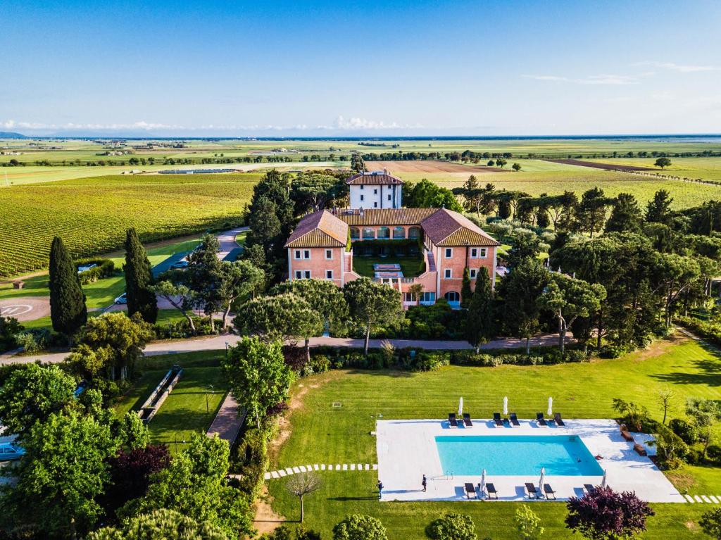 - une vue aérienne sur une grande maison avec une piscine dans l'établissement L'Andana Tenuta La Badiola, à Castiglione della Pescaia