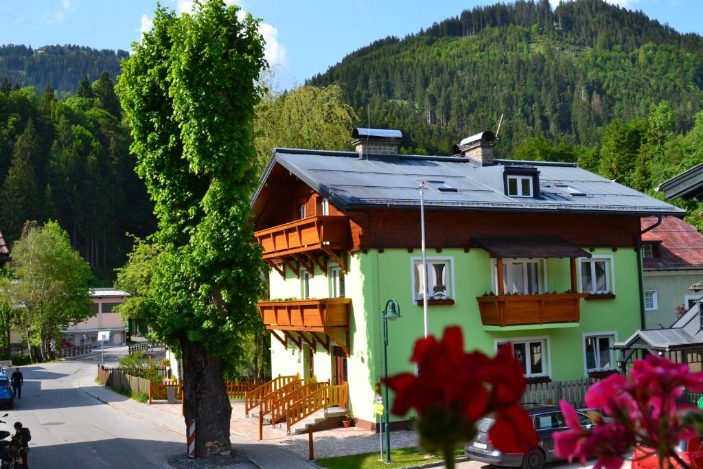 a house with a wooden roof and a tree at Apartment Holiday Lungötz in Annaberg im Lammertal