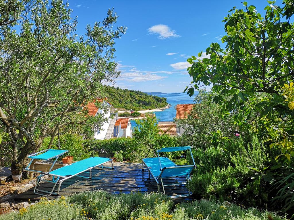 een groep blauwe stoelen op een terras met uitzicht op de oceaan bij Luxury apartment with own terrace and sea view in Trogir