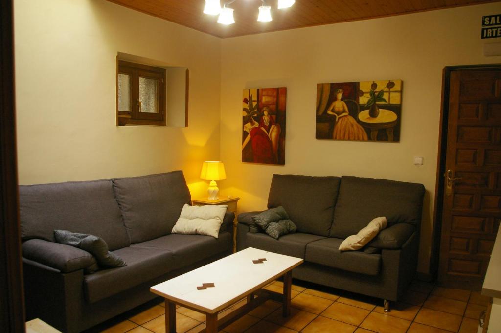 a living room with two couches and a table at Apartmento AZKOITI in Ochagavía