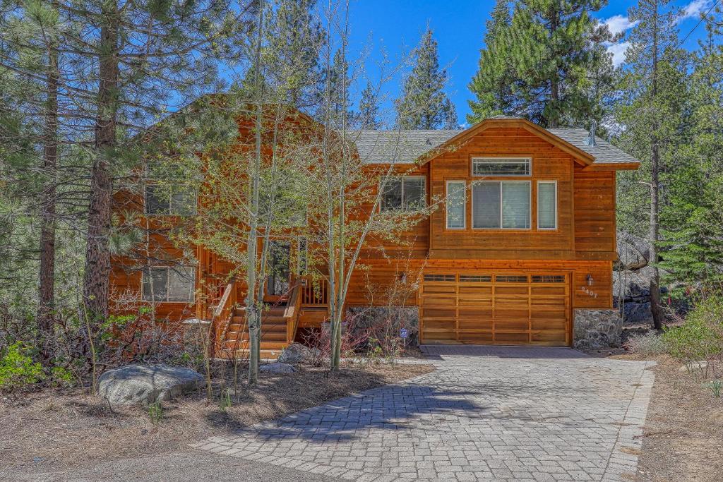 a wooden house with a garage in the woods at Montgomery Estates Retreat in South Lake Tahoe
