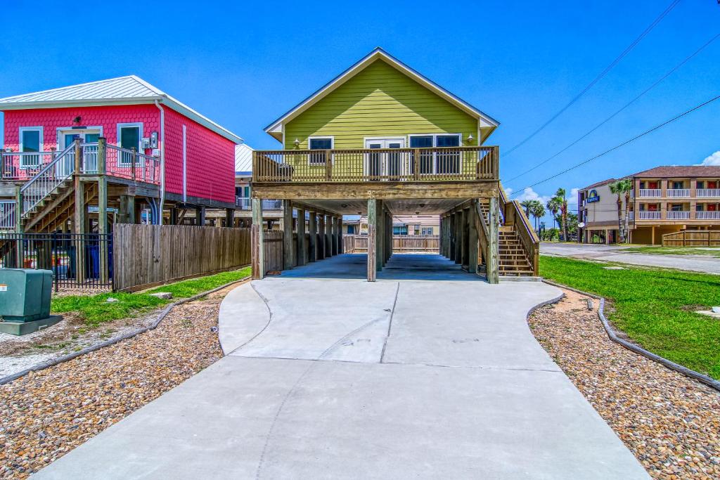 a house with a deck on a driveway at Breezy by the Beach in Corpus Christi