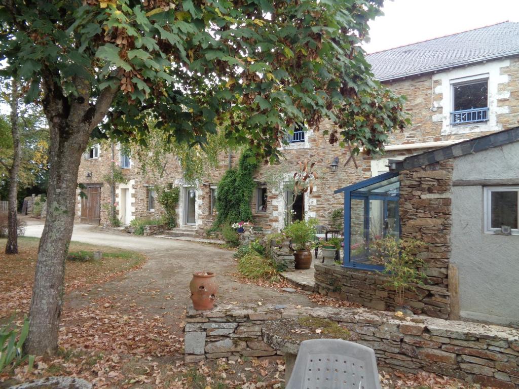 une maison en pierre avec une table et des chaises devant elle dans l'établissement Domaine du Bel Air, à Casson