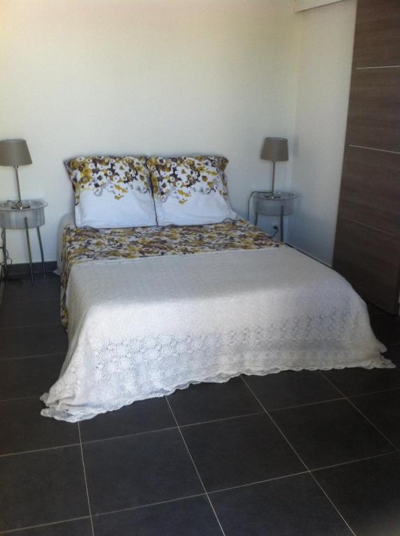 a bed in a room with two lamps on two tables at Gîte Polema in Marseille