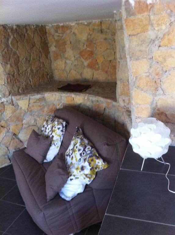 a couch in a stone wall with pillows on it at Gîte Polema in Marseille