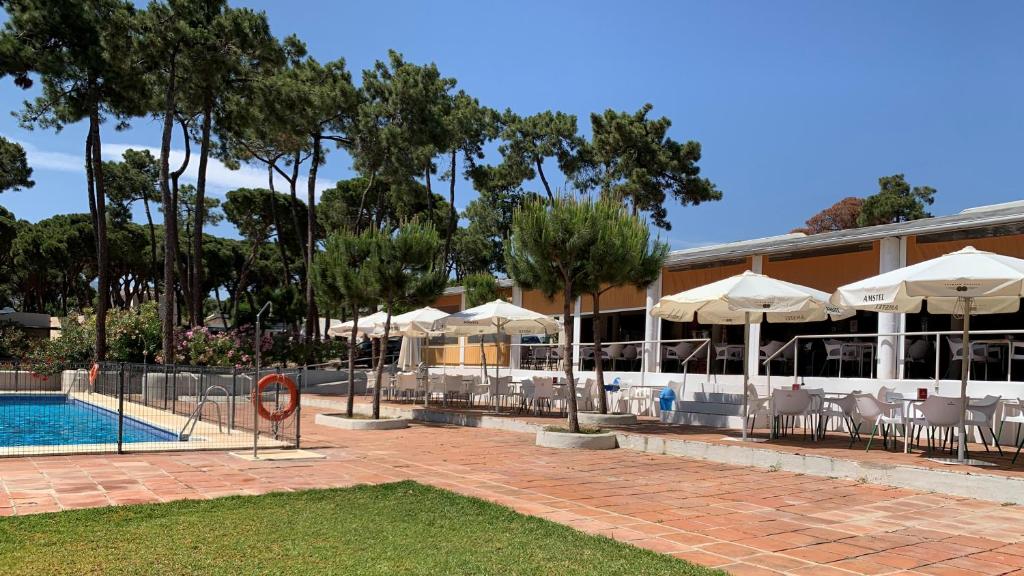 a resort with a pool and chairs and umbrellas at Camping La Buganvilla in Marbella