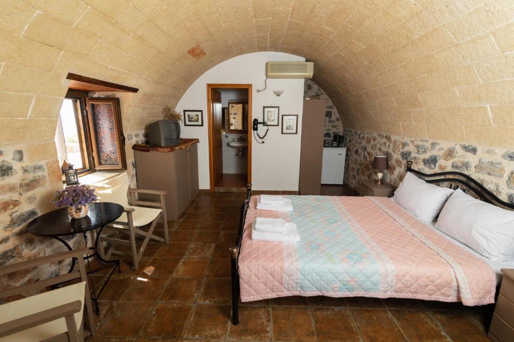 1 dormitorio con 1 cama y 1 mesa en una habitación en iliopetro en Monemvasia