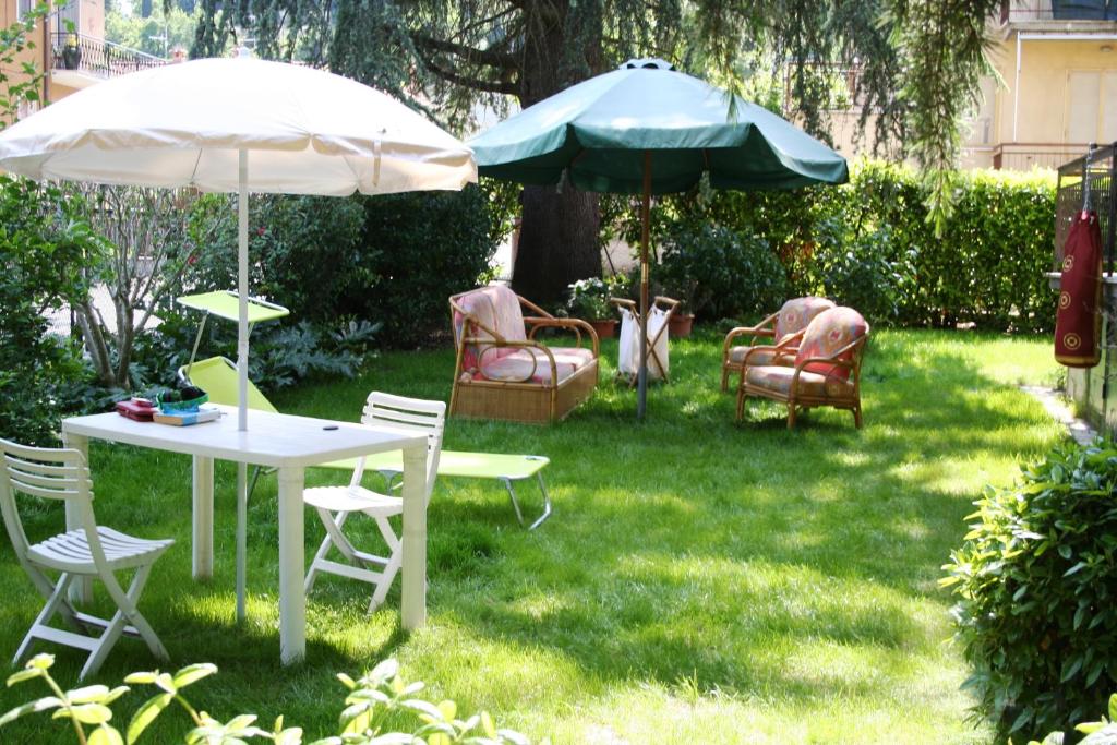 zwei Stühle und ein Tisch und zwei Sonnenschirme in einem Hof in der Unterkunft La casa di Rachele in Sarteano