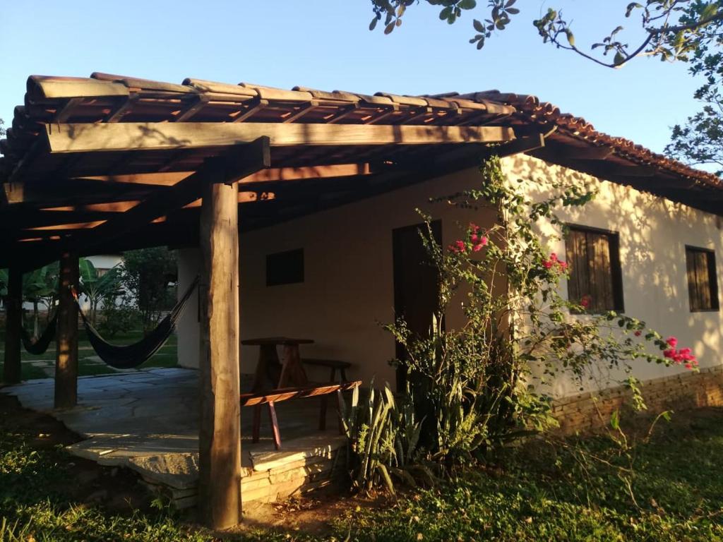 a wooden pergola in front of a house at Pousada Rio das Almas in Pirenópolis