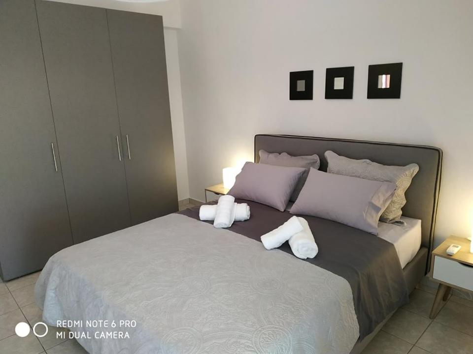 1 dormitorio con 1 cama con 2 toallas en Cosi Apartment, en Paralia Dionisiou