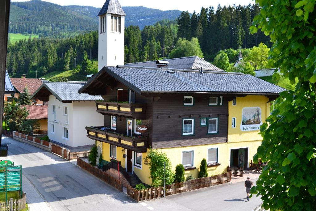 a building with a tower in the middle of a street at Pension Haus Rohrmoser in Annaberg im Lammertal