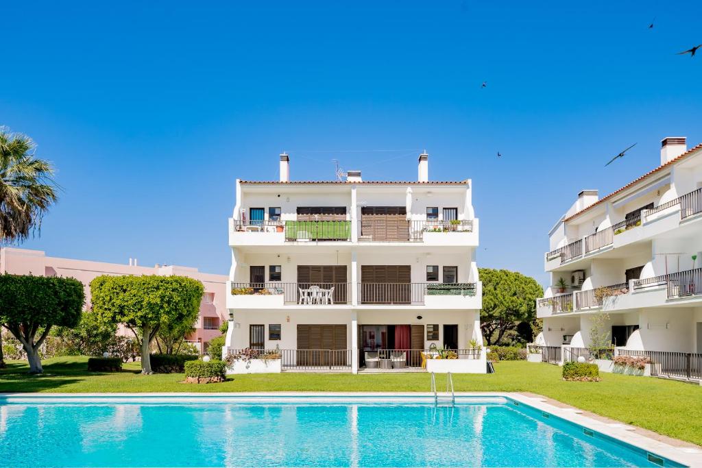 a building with a swimming pool in front of a building at Apartamento Moura Mar in Vilamoura