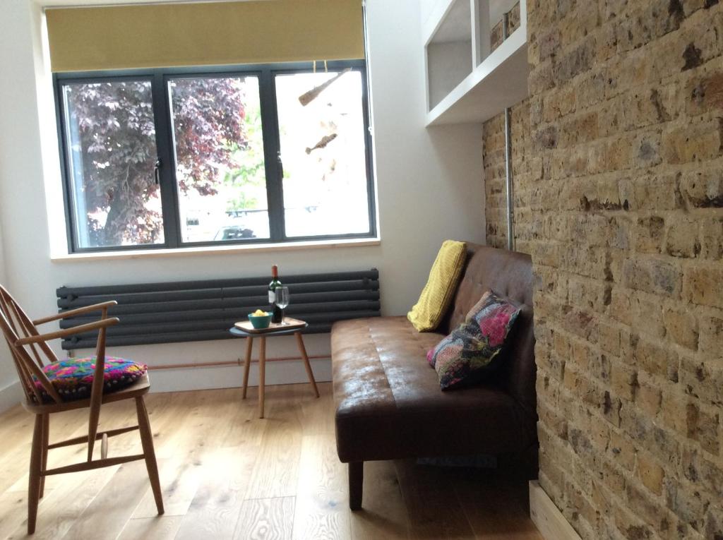 uma sala de estar com um sofá e uma parede de tijolos em Passengers House em Whitstable