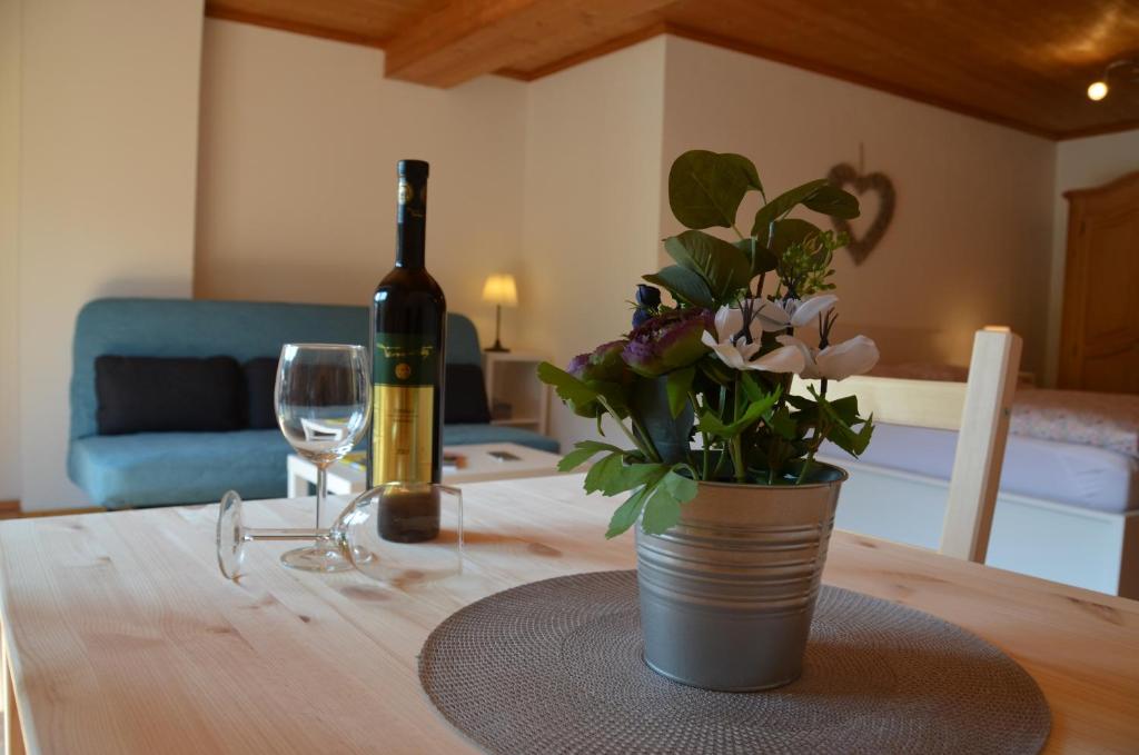 a bottle of wine and a vase of flowers on a table at City-apart Kitzbühel Stadt in Kitzbühel