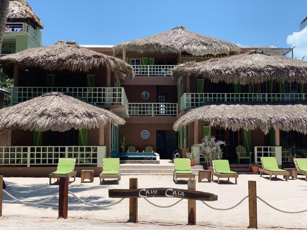 a sign in front of a resort with chairs and umbrellas at Caye Casa in San Pedro
