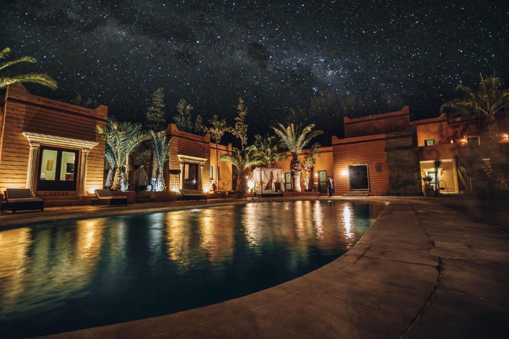 a large pool of water in front of a large building at Oscar Hotel by Atlas Studios in Ouarzazate