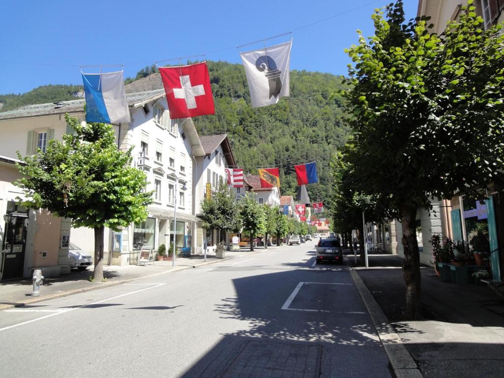 una calle vacía con banderas en un pueblo pequeño en Ferienwohnung Meiringen, en Meiringen