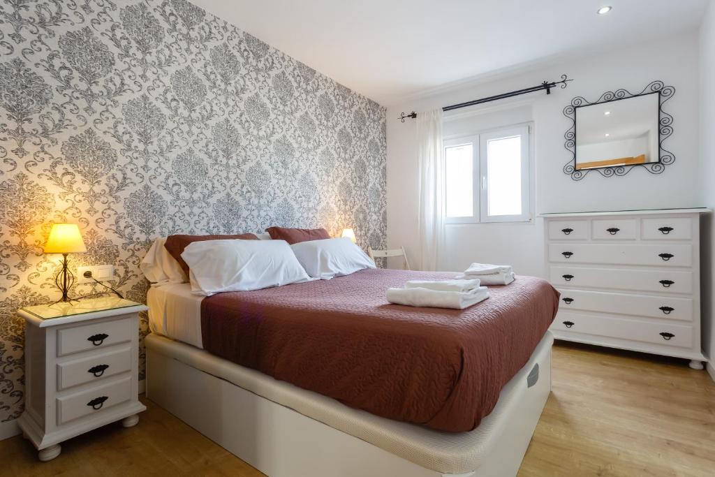 a bedroom with a bed with a dresser and a mirror at BARQUILLAS de la Caleta Home by Cadiz4Rentals in Cádiz
