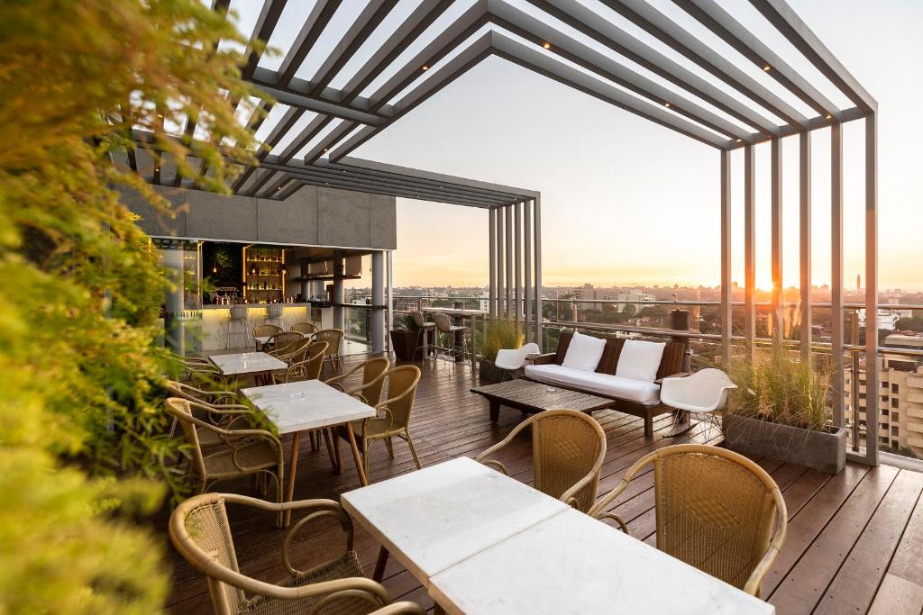 ein Restaurant mit Tischen und Stühlen auf einem Balkon in der Unterkunft Hub Hotel Asuncion in Asunción