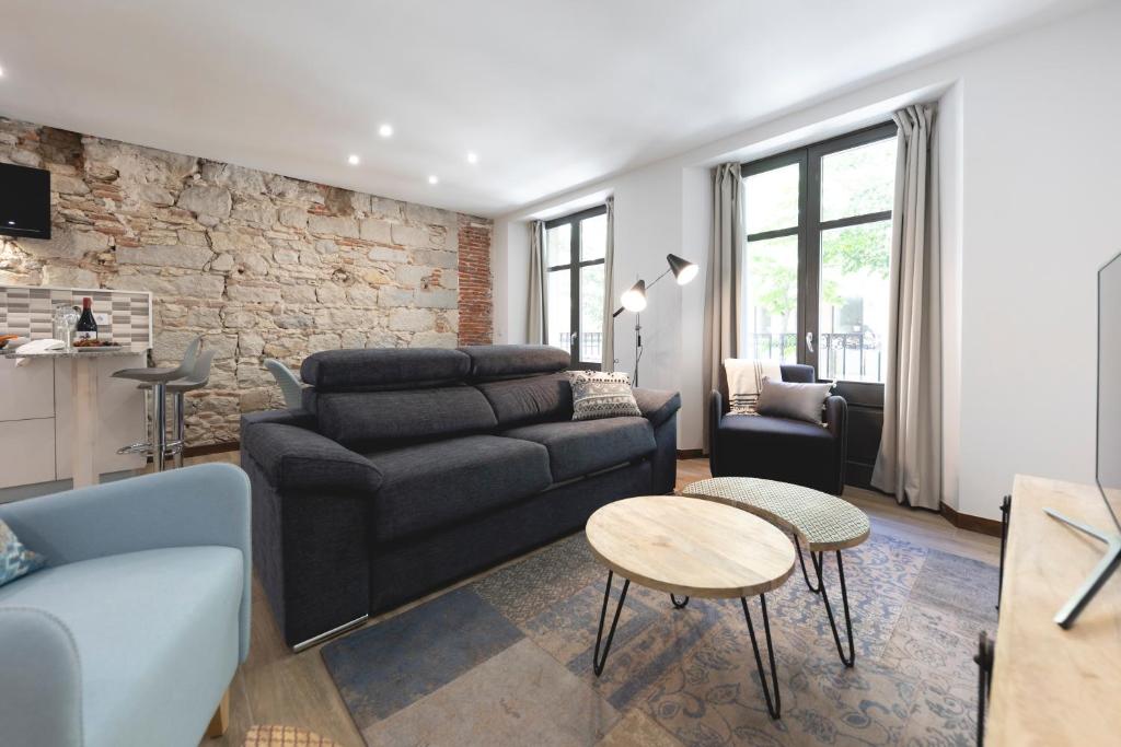 a living room with a couch and a table at Bravissimo Rambla Eiffel Bridge 1 in Girona