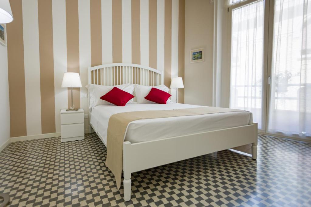 Un dormitorio con una gran cama blanca con almohadas rojas. en B&B Kalavrìa, en Reggio Calabria