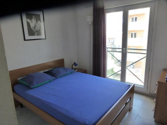 ニースにあるPalais des Domes Gloriaのベッドルーム(青いベッド1台、大きな窓付)