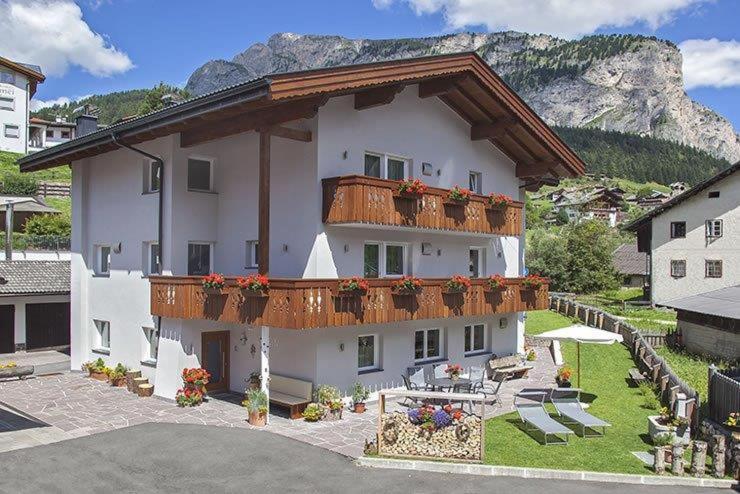 a large white building with a balcony with flowers on it at Villa Seceda in Selva di Val Gardena