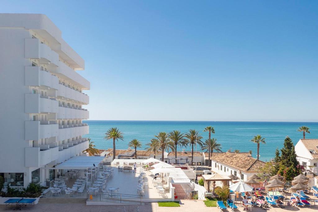 uma vista para um resort com uma praia e o oceano em Hotel Palia La Roca em Benalmádena
