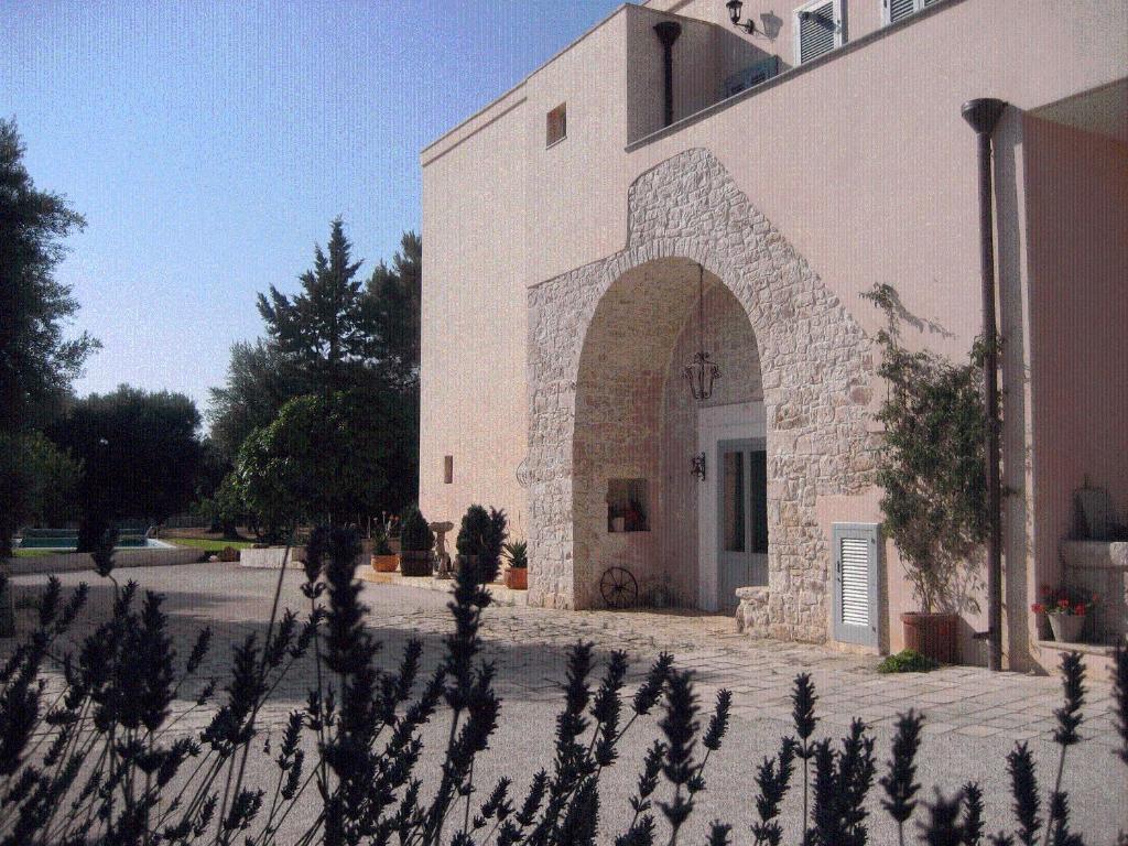 a building with an archway in front of it at Masseria Due Torri in Monopoli