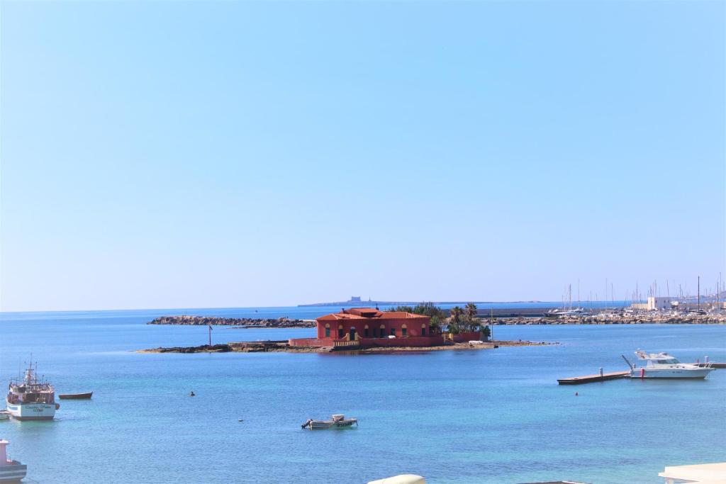 una piccola isola in mezzo all'acqua con barche di TOREMARE SUITE MARZAMEMI a Marzamemi