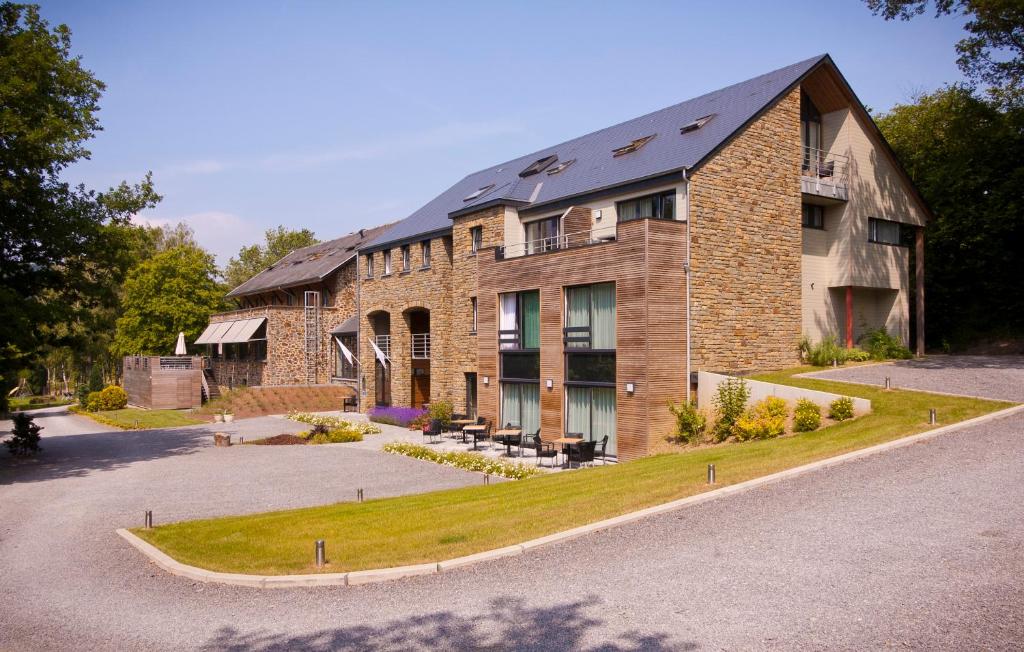 een groot bakstenen gebouw met een binnenplaats ervoor bij Hotel - La Grande Cure in Marcourt