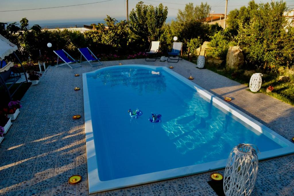 a swimming pool with blue water in a yard at * * * VILLA ANNALISA * * * in Casteldaccia