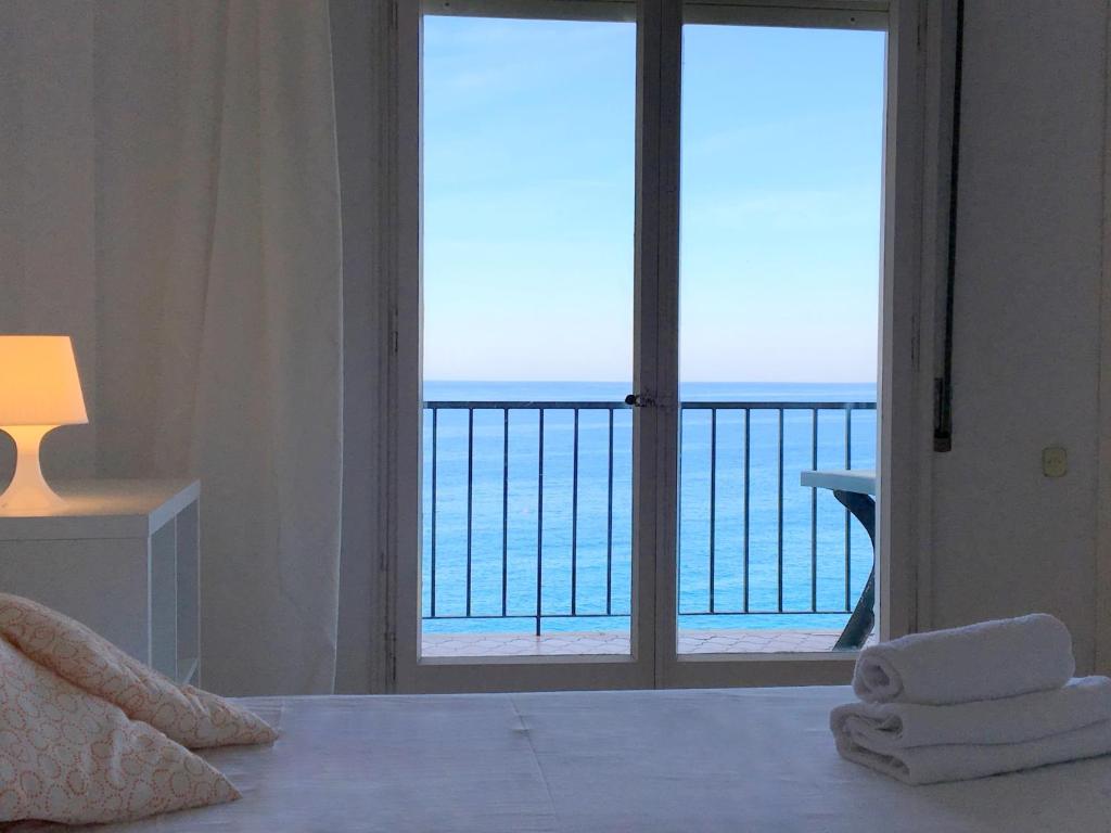 a bedroom with a view of the ocean from a balcony at LES TERRASSES de Cala Llevado in Tossa de Mar
