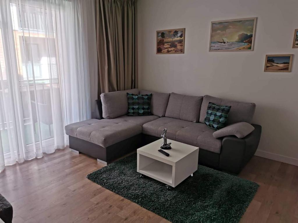 - un salon avec un canapé et une table dans l'établissement Maluno Vila Apartment, à Palanga